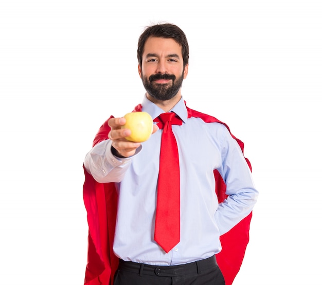 Hombre de negocios vestido como superhéroe sosteniendo una manzana