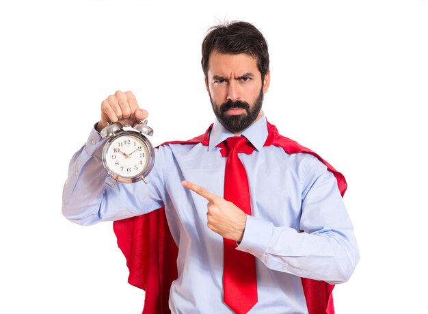 Hombre de negocios vestido como superhéroe sosteniendo un reloj