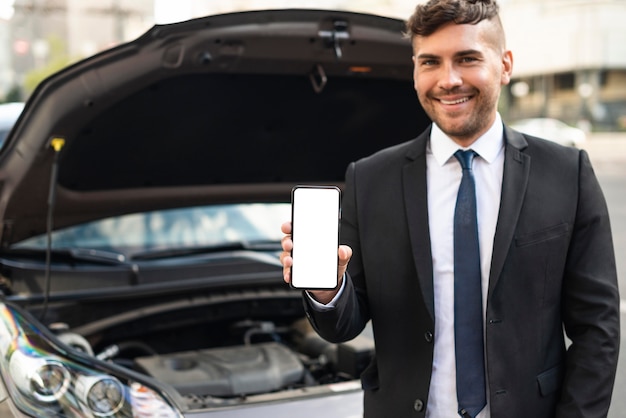 Hombre de negocios de vista frontal sosteniendo teléfono móvil