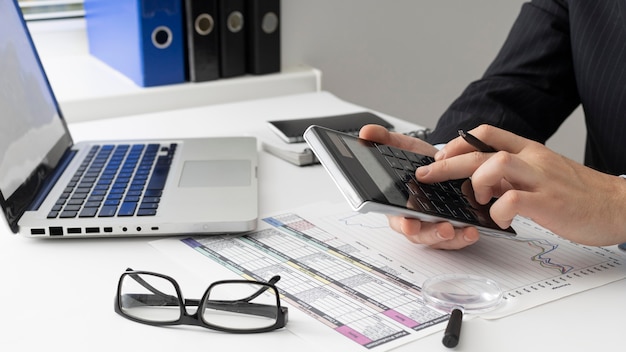 Hombre de negocios de vista lateral calcular números de finanzas