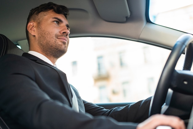 Hombre de negocios de vista lateral conduciendo