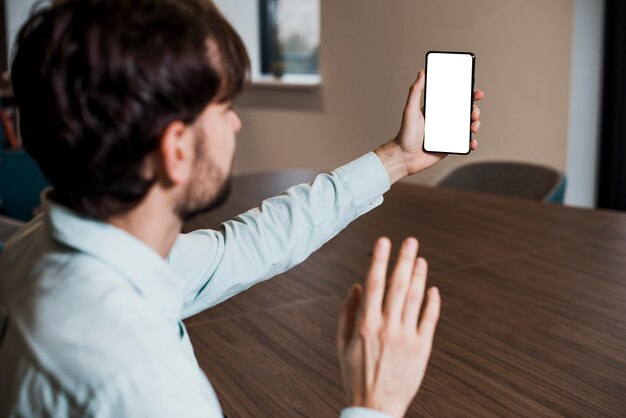 Hombre de negocios de vista lateral hablando por una videollamada