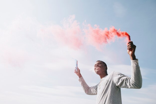 Hombre negro con bombas de humo de colores