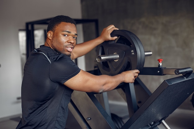 Un hombre negro guapo se dedica a un gimnasio