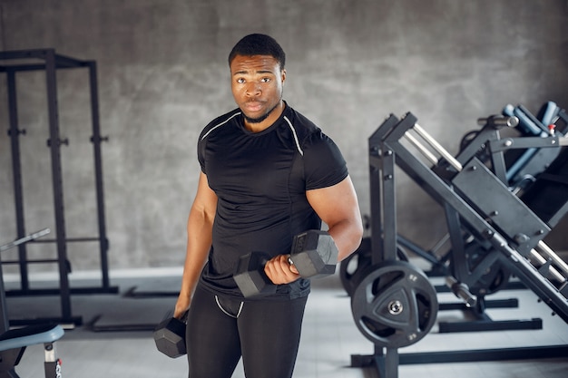 Un hombre negro guapo se dedica a un gimnasio