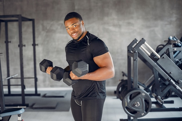 Un hombre negro guapo se dedica a un gimnasio