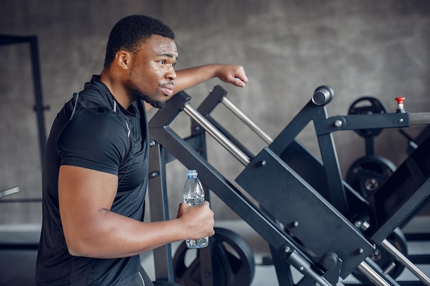 Un hombre negro guapo se dedica a un gimnasio