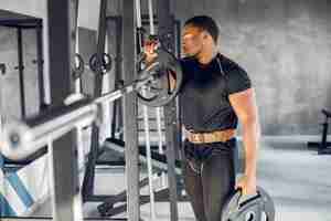 Foto gratuita un hombre negro guapo se dedica a un gimnasio