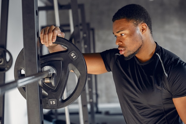 Un hombre negro guapo se dedica a un gimnasio