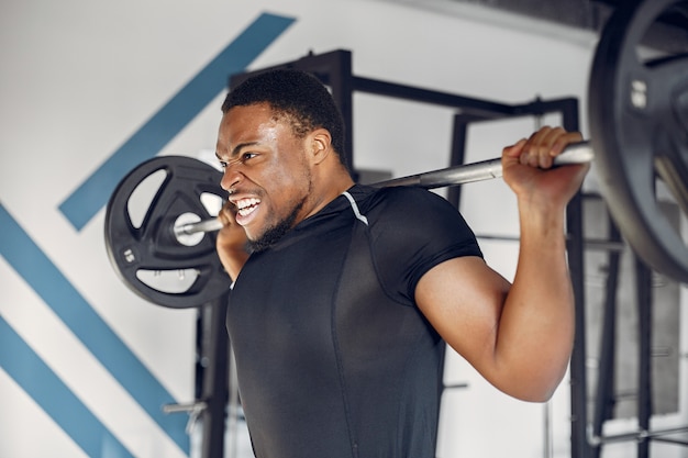 Un hombre negro guapo se dedica a un gimnasio