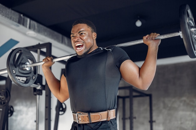 Un hombre negro guapo se dedica a un gimnasio