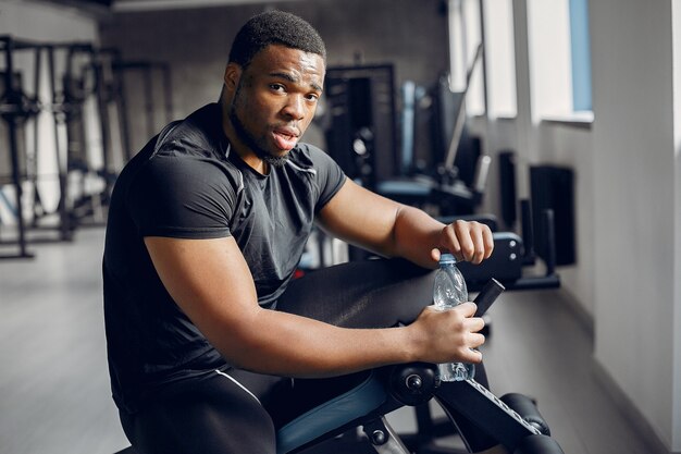 Un hombre negro guapo se dedica a un gimnasio