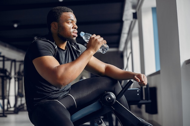 Un hombre negro guapo se dedica a un gimnasio