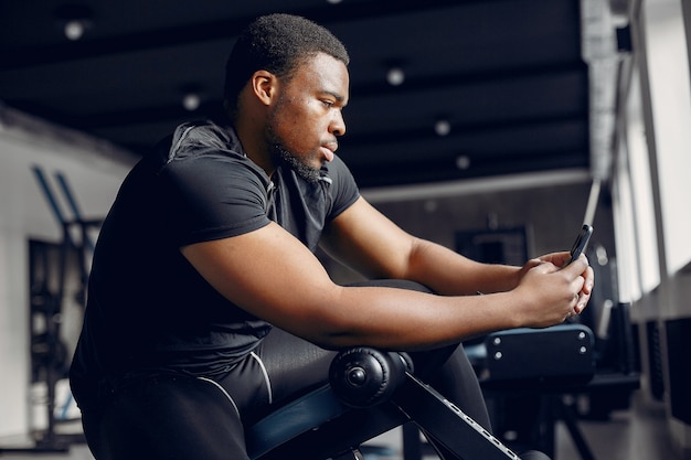 Un hombre negro guapo se dedica a un gimnasio