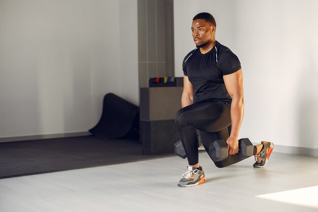 Un hombre negro guapo se dedica a un gimnasio