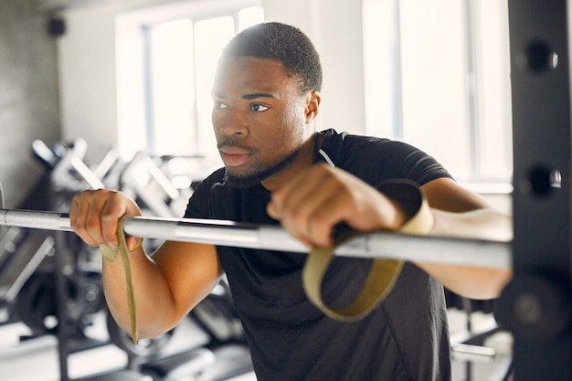 Un hombre negro guapo se dedica a un gimnasio