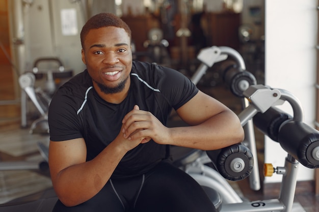 Un hombre negro guapo se dedica a un gimnasio