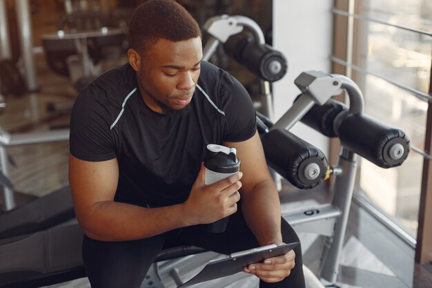 Un hombre negro guapo se dedica a un gimnasio