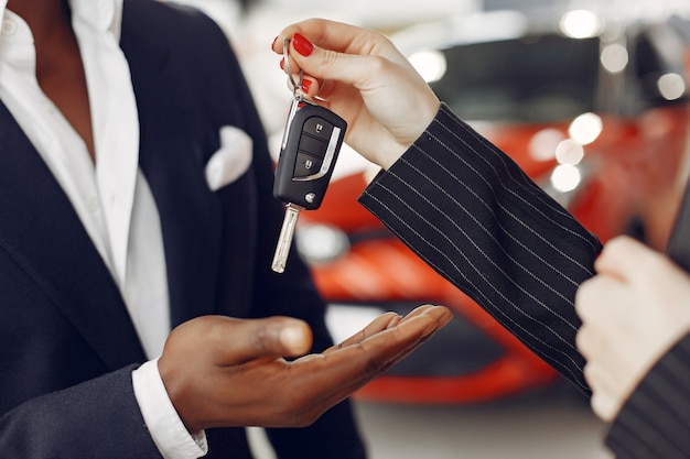 Hombre negro guapo y elegante en un salón del automóvil