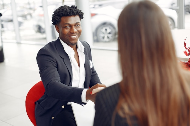 Hombre negro guapo y elegante en un salón del automóvil