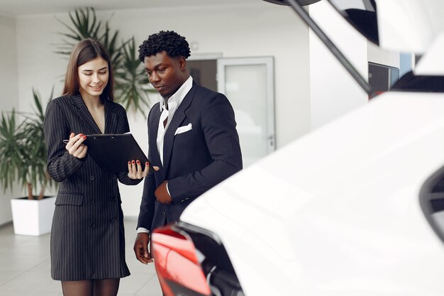 Hombre negro guapo y elegante en un salón del automóvil