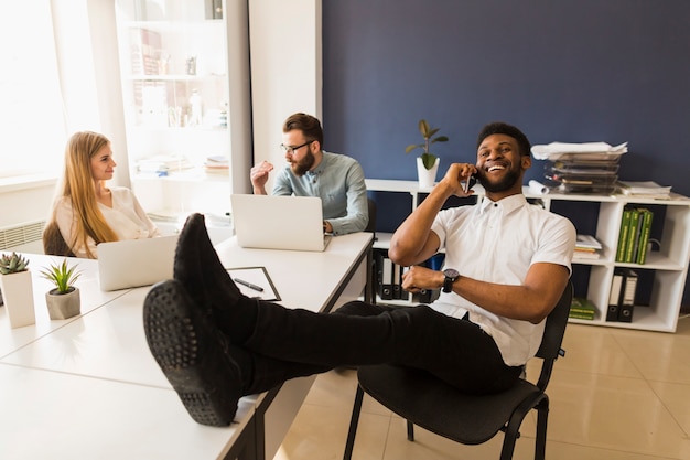 Foto gratuita hombre negro hablando por teléfono en la oficina