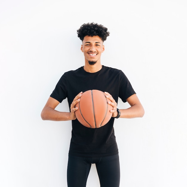 Hombre negro joven con el baloncesto que mira la cámara