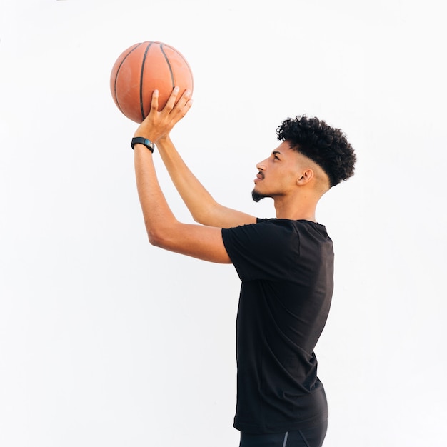 Hombre negro joven que se prepara para lanzar baloncesto