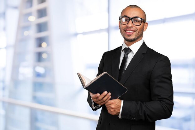 Hombre negro de negocios sosteniendo un libro