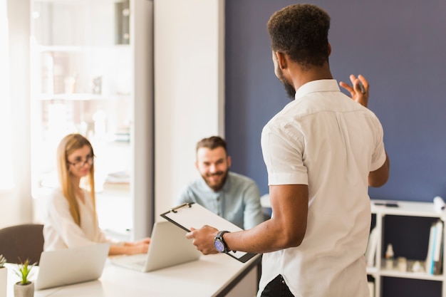 Hombre negro que presenta la estrategia a los compañeros de trabajo