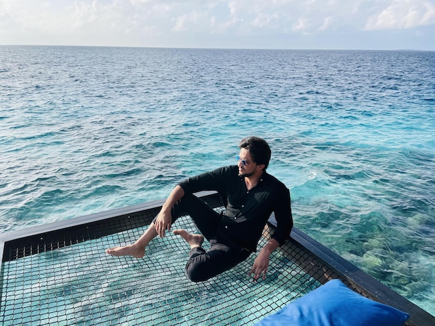 Foto gratuita hombre de negro sobre un muelle de madera en las maldivas