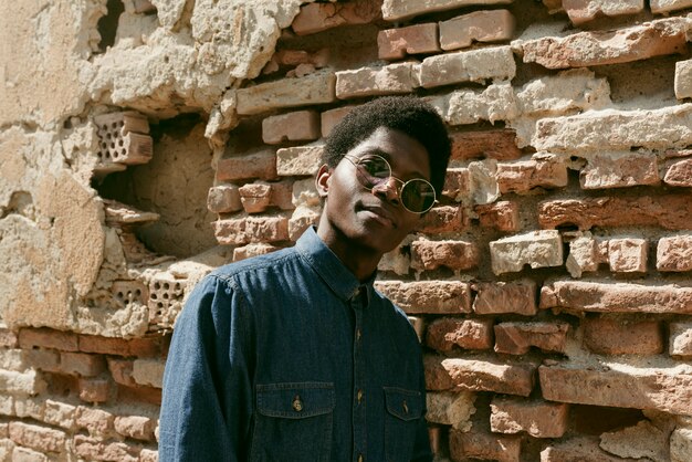 Hombre negro de tiro medio posando con gafas de sol