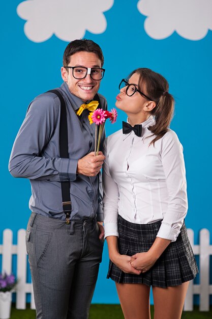 Hombre nerd dando flores a su novia pareja
