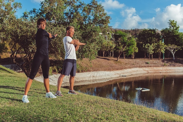 Foto gratuita hombre y niña haciendo calentamiento en el parque.