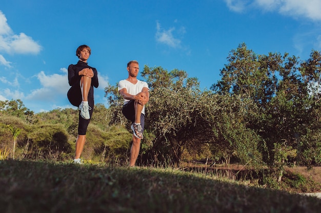 Hombre y niña haciendo calentamiento en el parque.