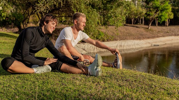 Hombre y niña haciendo calentamiento en el parque.