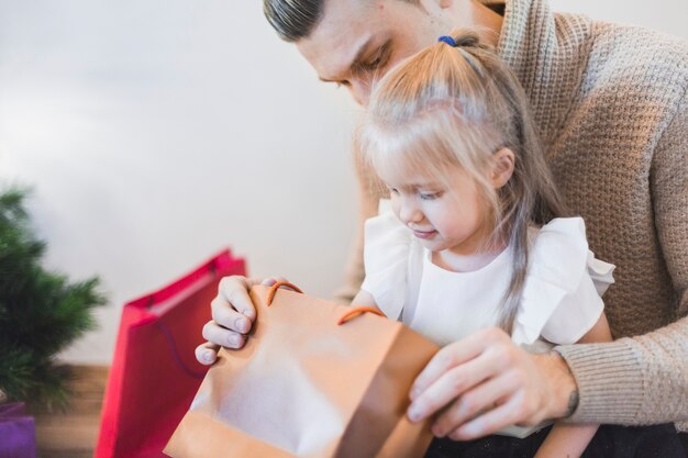 Hombre y niña mirando en bolsa en navidad