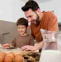 Foto gratuita hombre y niño de tiro medio en la cocina