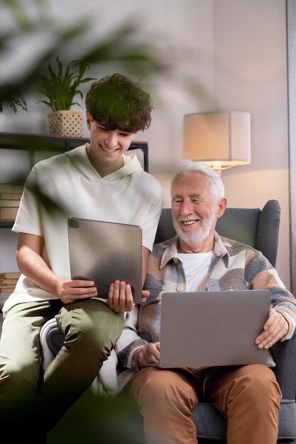 Hombre y niño de tiro medio con dispositivos.