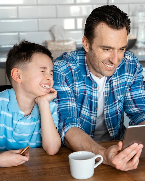 Foto gratuita hombre y niño de tiro medio con tableta