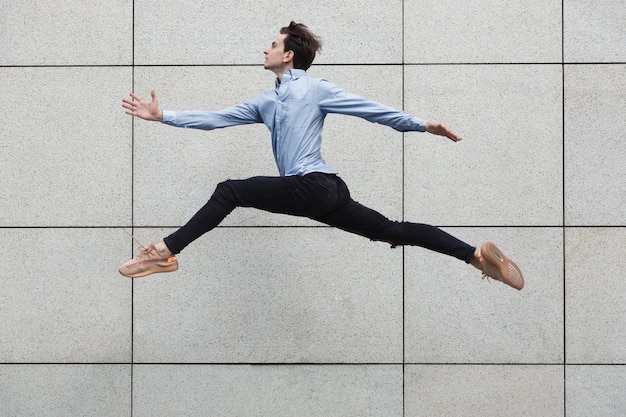 Hombre de oficina de salto en la ciudad, bailarina de ballet