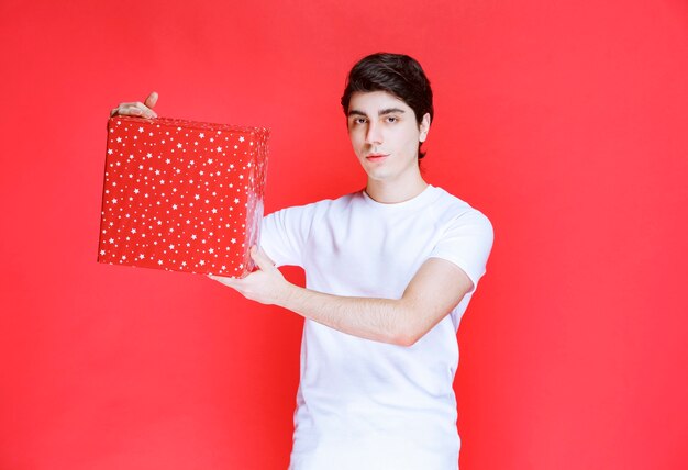 Hombre ofreciendo una caja de regalo roja en el día de San Valentín