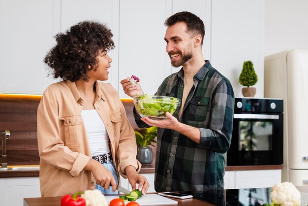 Hombre ofreciendo ensalada a su novia