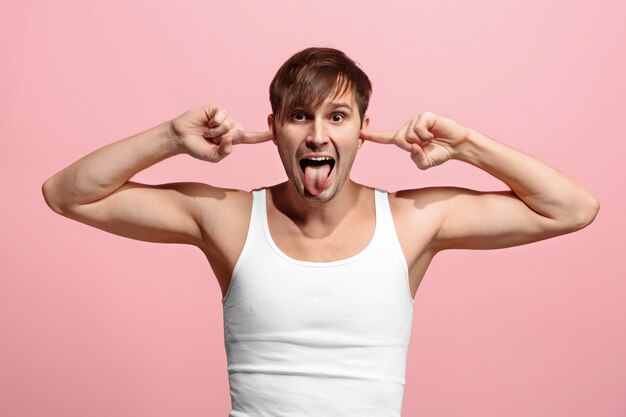 El hombre de ojos bizcos con expresión extraña aislado en la pared rosa