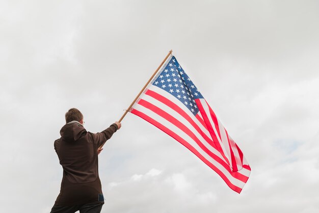 Hombre ondeando bandera americana