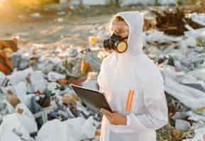 Foto gratuita hombre en overoles en la píldora de la basura. investigando. concepto de ecología, contaminación ambiental.