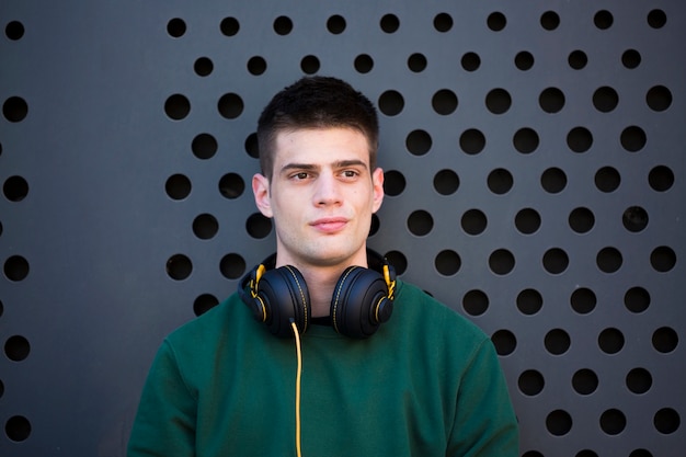 Hombre pacífico joven con los auriculares que miran lejos