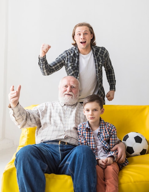 Foto gratuita hombre con padre e hijo viendo partido de fútbol