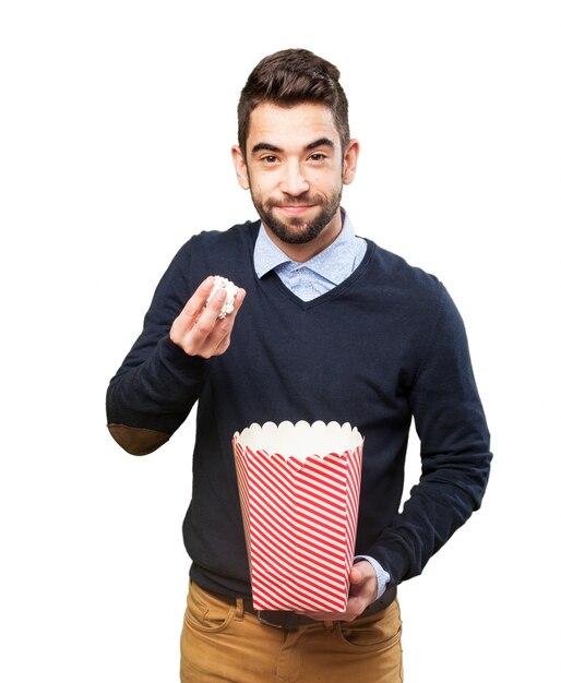 Hombre con palomitas en una mano y un paquete en la otra