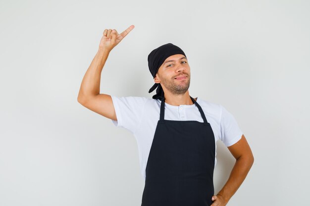 Hombre panadero apuntando hacia el lado con el dedo hacia arriba en la camiseta